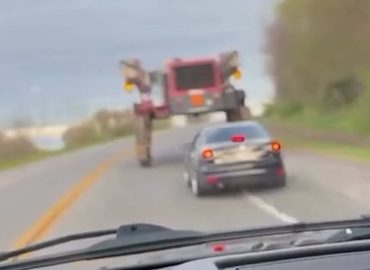US-Fahrer fahren unter Landmaschine hindurch