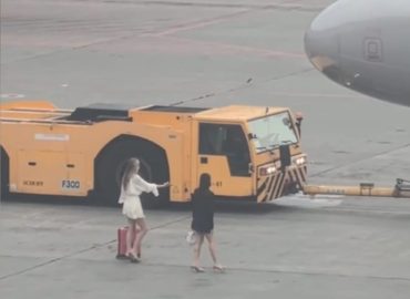 Zwei Frauen verfolgen Flugzeug auf Moskauer Rollfeld