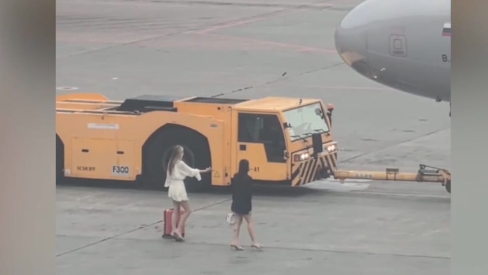 Zwei Frauen verfolgen Flugzeug auf Moskauer Rollfeld