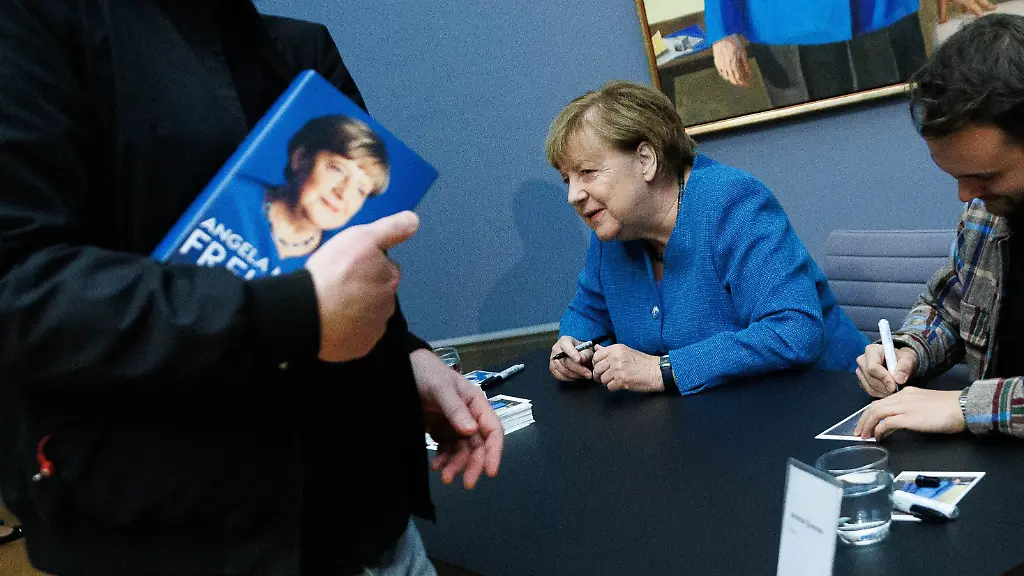 Merkel signiert Kunstpostkarten ihres Porträts im Bode-Museum